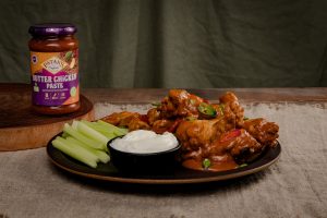 Butter chicken wings tossed in a creamy butter chicken sauce, served with celery sticks, sliced green chilli and a bowl of Greek yoghurt